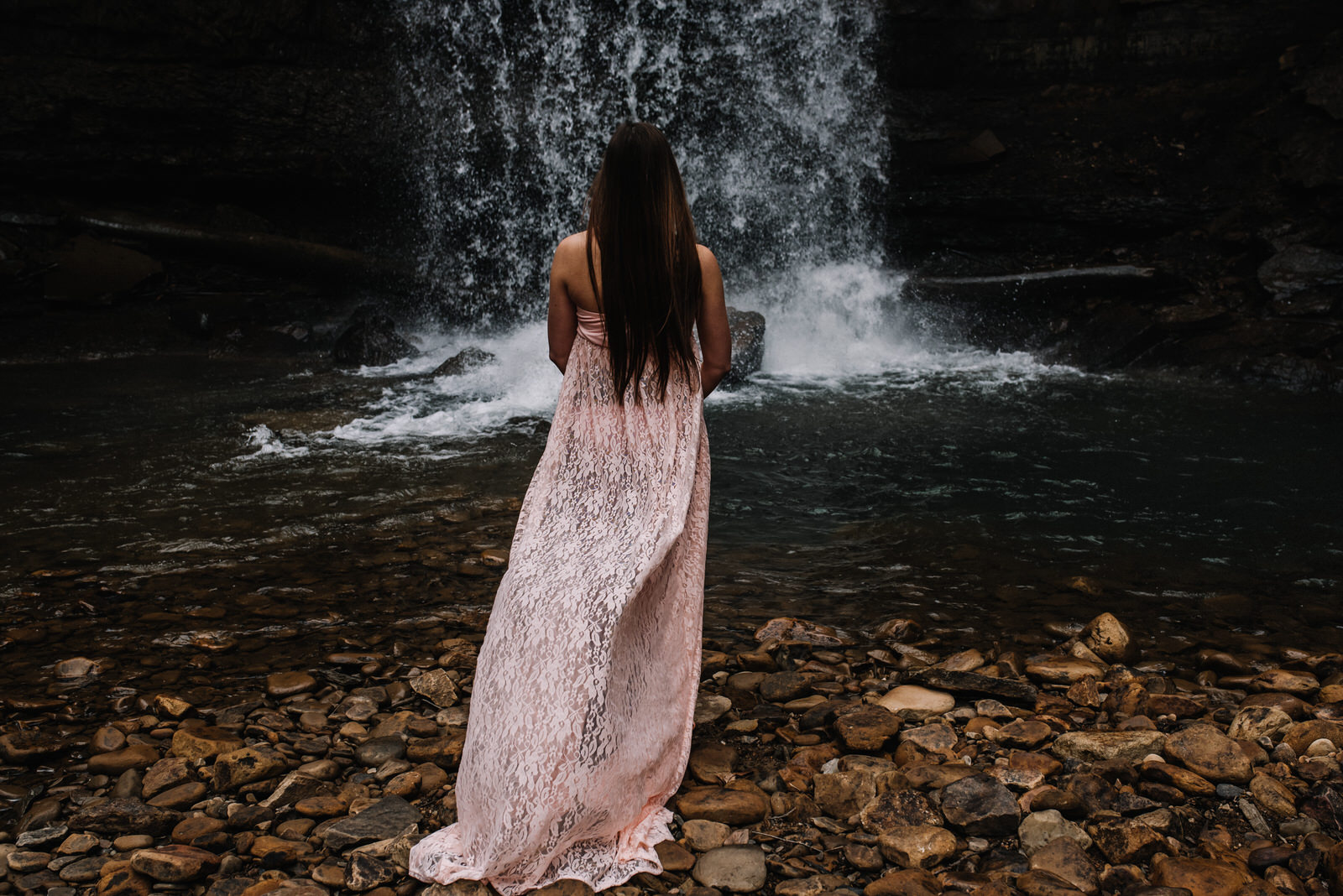  mom stands near waterfall at cucumber falls in ohiopyle for maternity session 